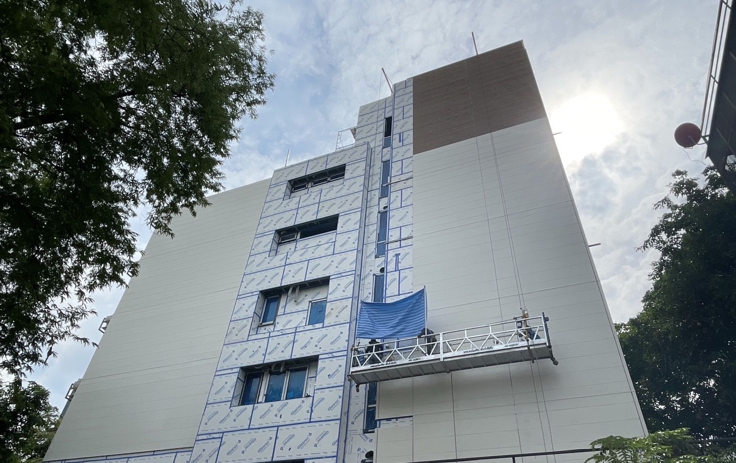อาคาร Sathorn Residence 7 ชั้น ระหว่างก่อสร้าง ผนังภายนอกบุแผ่น Glasroc X ช่างบนกระเช้ากำลังติดตั้งแผ่นผนัง